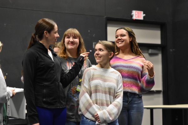 Cast members Alexa Grubb, 11, Makenna Brodberick, 11, Olivia Brenner, 11, and Amara Amadi, 10, share a laugh while learning the choreography for Shes in Love during rehearsal.