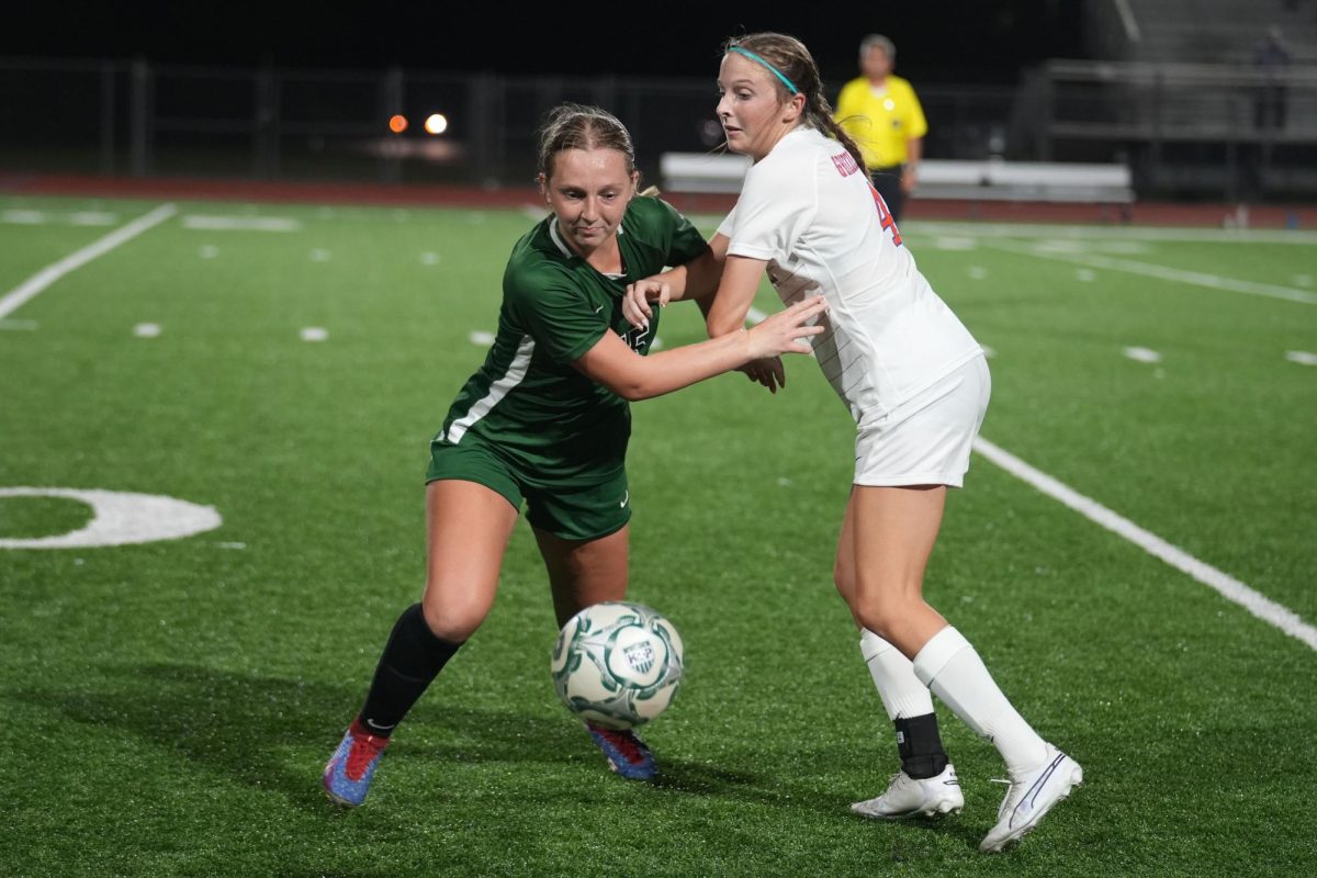 Senior midfielder Brynn Baldon fights off a defender in a 2-1 victory over Grand Oaks in the teams first scrimmage of the year. Baldon scored both goals in the game. 