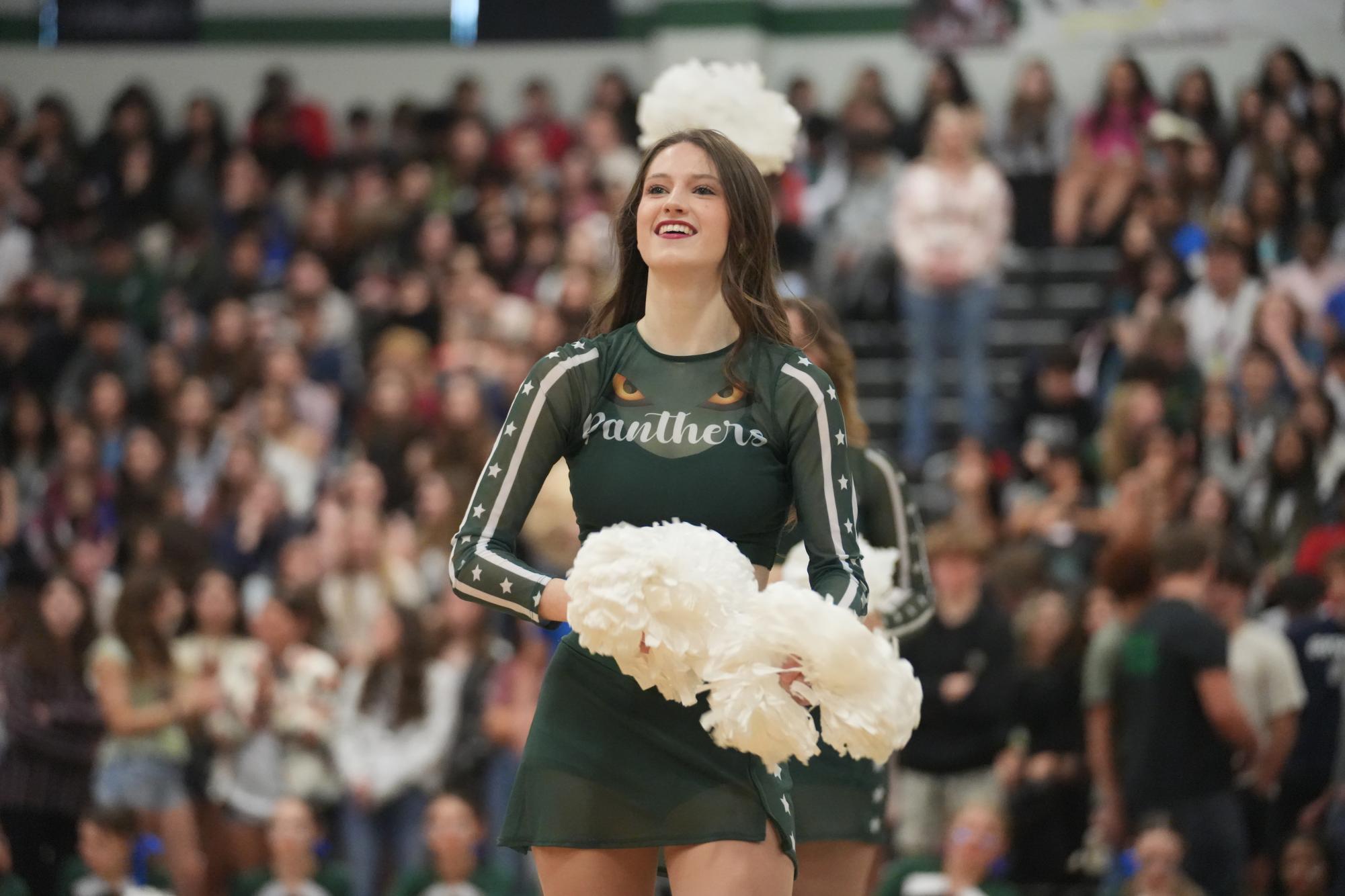 Senior Mary Brown claps with poms at pep rally with All Stars.