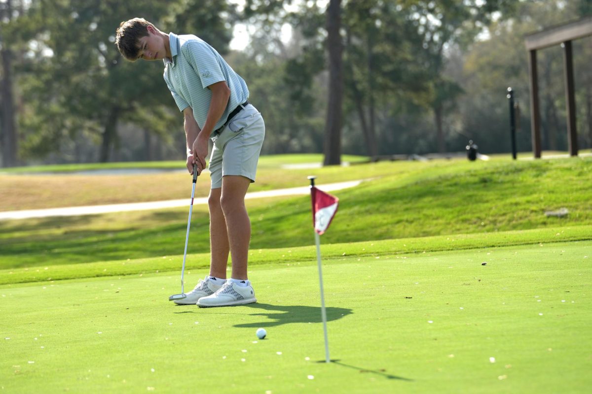 Sophomore+Cory+Case+putts+during+practice+at+Kingwood+Country+Club.+He+has+been+swinging+a+golf+club+since+he+was+4+years+old.+