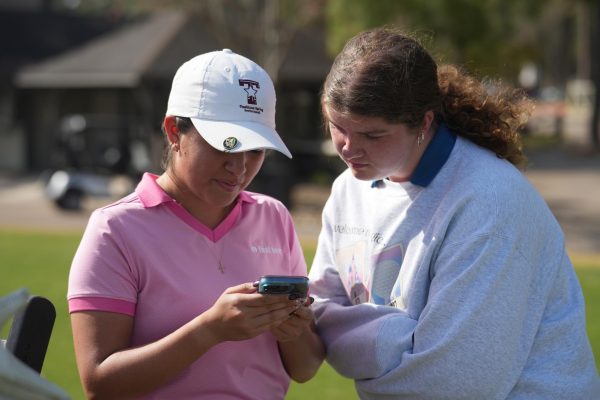Seniors Leah Torres and Grace Darcy take a break together between practice swings before the district meet. The two were part of the varsity squad that finished second in Districts and advanced to the Regional tournament.