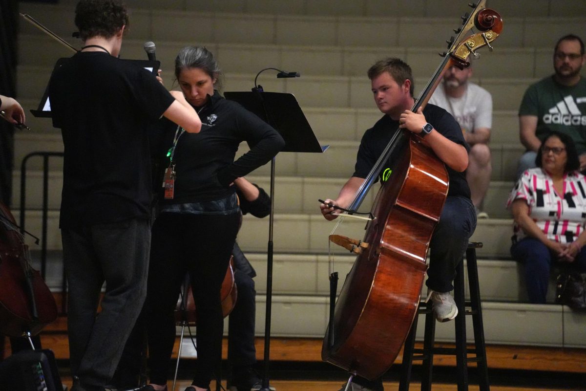 Senior Hugo Houel plays the cello while performing with other seniors in orchestra during Senior Glowcase.