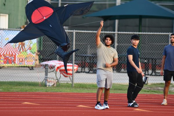 Senior Enrique Guzman starts to fly a kite off the track at Senior Sunset.