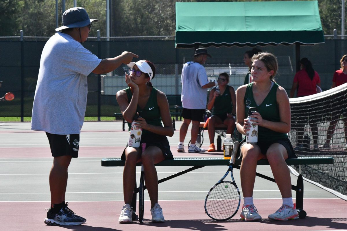 Tennis+coach+John+Macapaz+talks+to+seniors+Luvenia+Wallace+and+Brooke+OBrien+during+a+match+against+Porter+in+the+fall.+The+two+won+the+District+doubles+title+in+the+spring+and+advanced+to+Region.