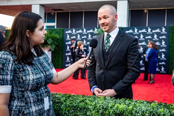 Senior Maya Ortiz interviews history teacher Eric Coovert on the red carpet prior to the Houston Sports Awards in January. Ortiz served as a correspondent for Humble ISD as Coovert received the Inspiration Award. Photo by Joshua Koch. 