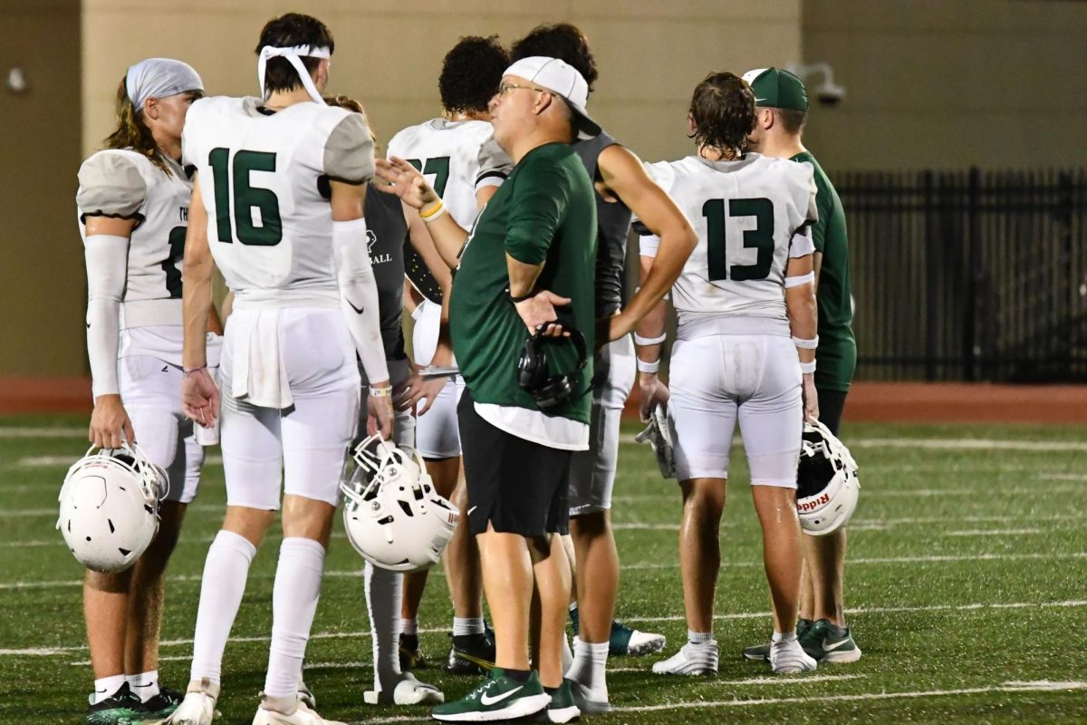 Offensive coordinator Scott Elliott talks with quarterback Bode Cox and Aaron Gilliam after the team's scrimmage against Tomball on Aug. 15. 