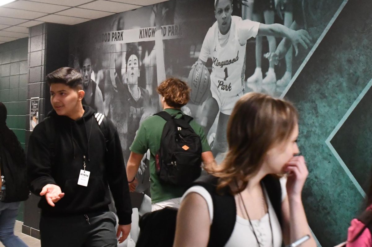 Students walk through the new hallway in the athletic wing, which now showcases photos of volleyball and basketball players.