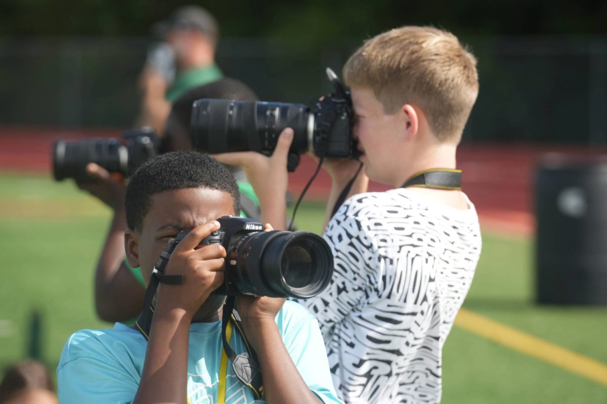 Campers at the Summer Media Camp photograph soccer practice during the second day of the journalism camp.