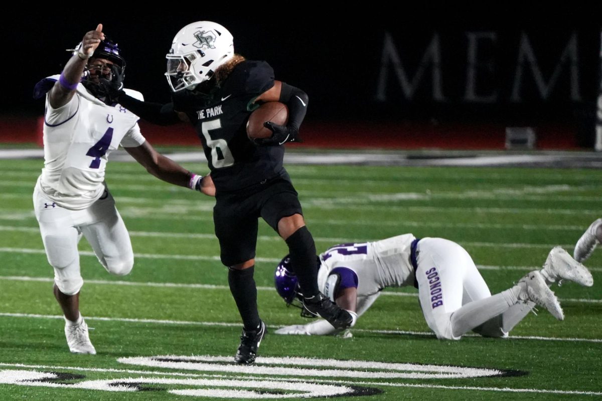 Sophomore Kye Wehby fights to beat two defenders as he carries the ball against Dayton on Sept. 6. 