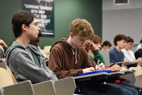 Senior Jonas Ermel fills out a voting registration form during his first period government class in the LGI.