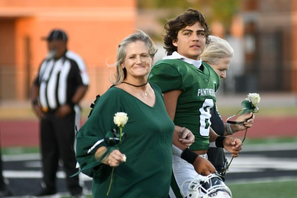 Senior running back Chris Lora is escorted on the field by his mom and grandparents prior to the Senior Night game at Turner Stadium on Oct. 24. Lora was in a three-car accident earlier in the day. 