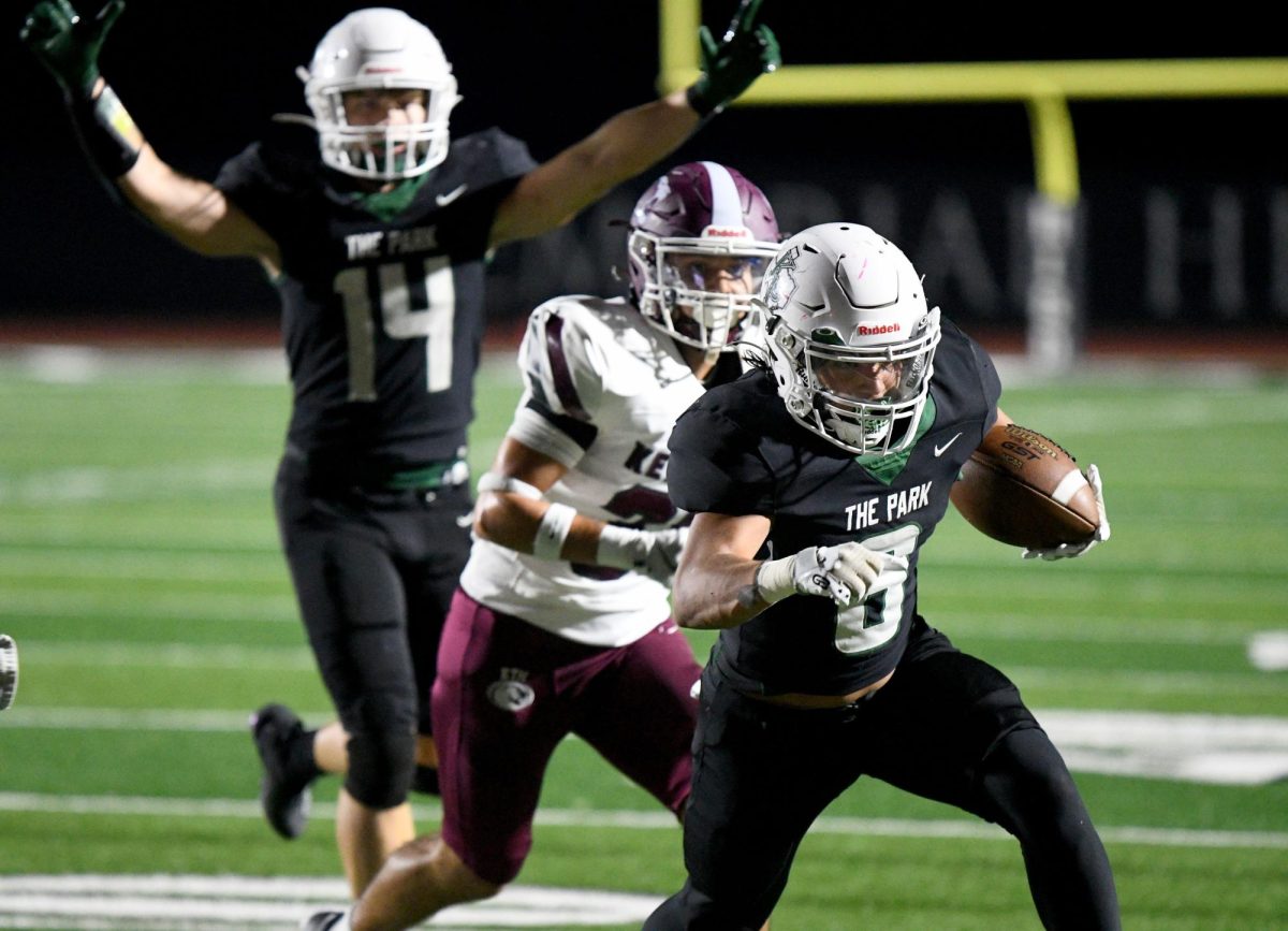 Senior Christian Lora runs into the endzone to get a touchdown,while senior Ethan Elliott celebrates behind him.