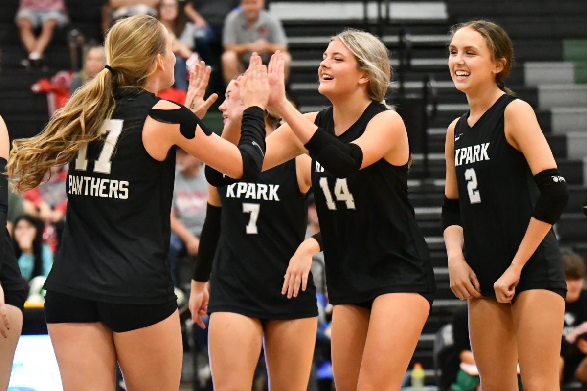 Junior Kaely Evans high fives junior Lily Medina as junior Emma Abel celebrates with them against Splendora.