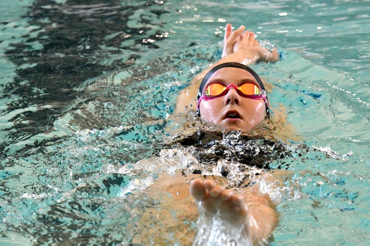 Sophomore Courtney Scott warms up the backstroke before a swim meet earlier this season against Summer Creek. Scott started swimming 13 years ago and is on her second year on varsity. 