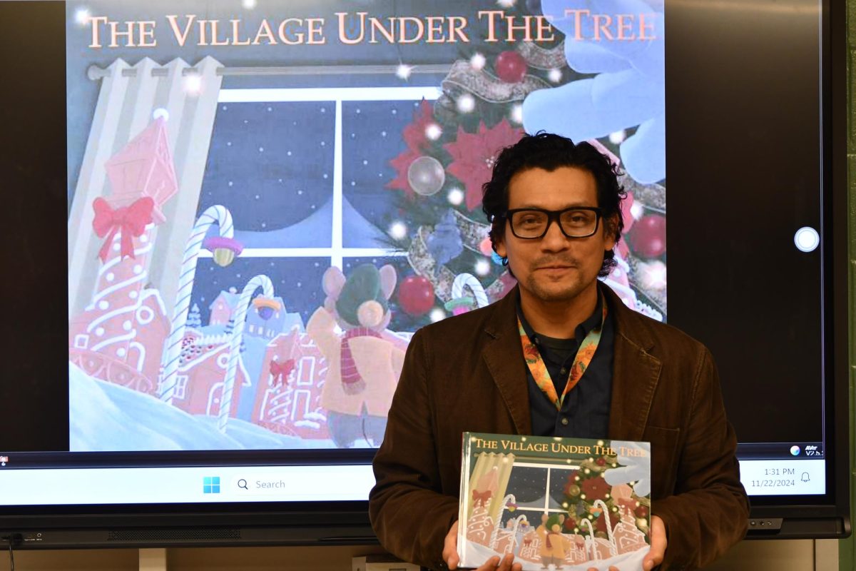 Art teacher Miguel Alvarez holds the book he spent seven years writing and illustrating. It was published earlier this month.