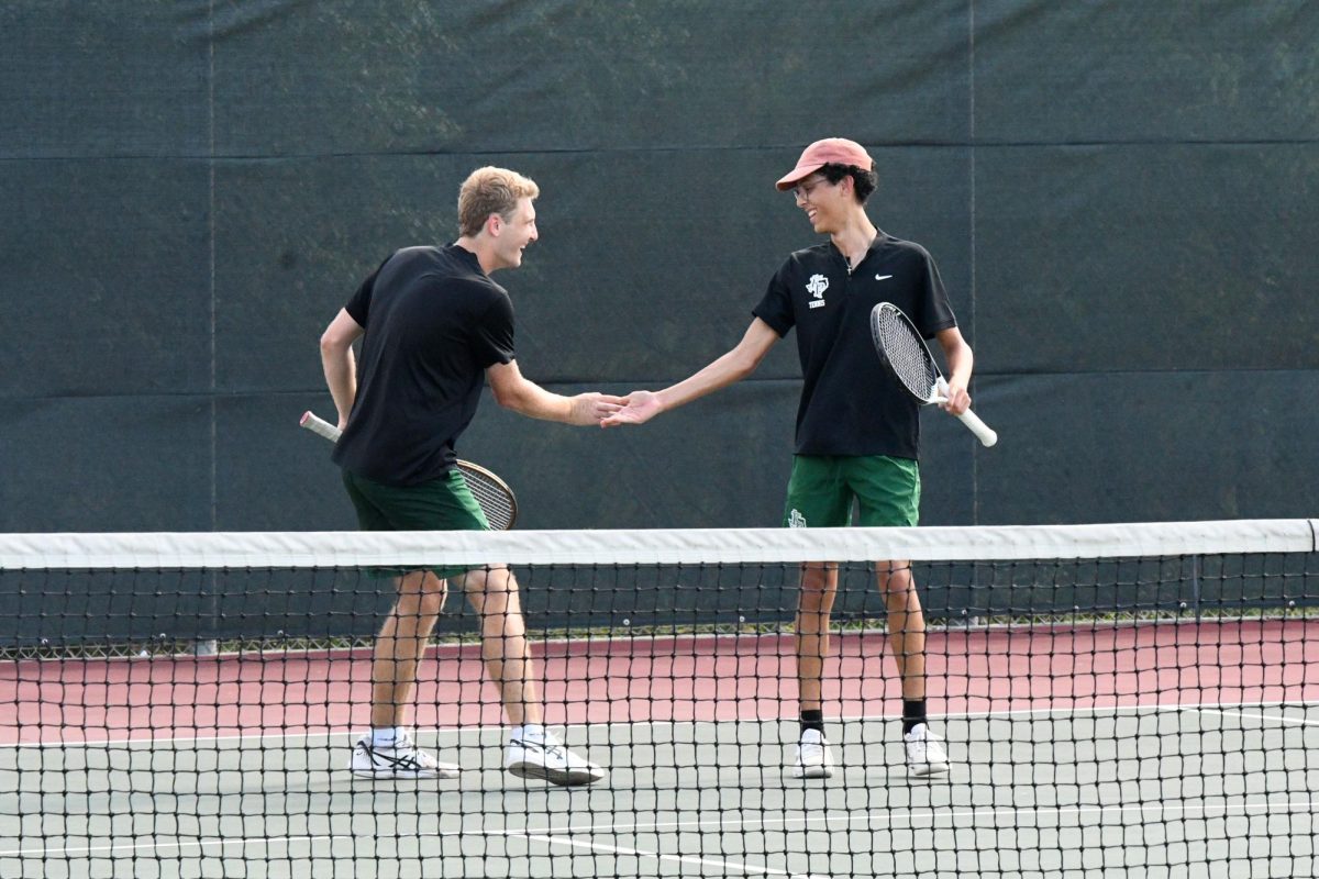 Senior Andrew Carson and doubles partner Santiago Santiago congratulate each other after getting a point during their doubles match against MacArthur.