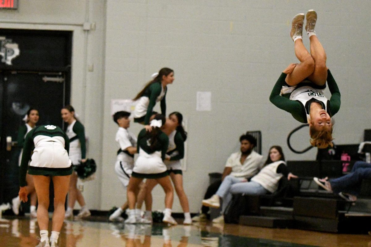 Junior Madi Staggs does a backflip during a routine while there's a break in the game.