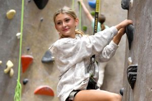 Sophomore Madi Moffitt looks back at her teammates as she climbs the rock wall at inSPIRE Rock on Dec. 4. 