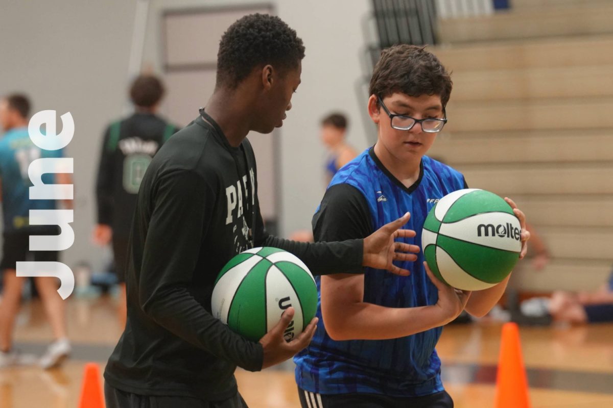 The boys basketball team worked to teach the basic skills to campers in June.