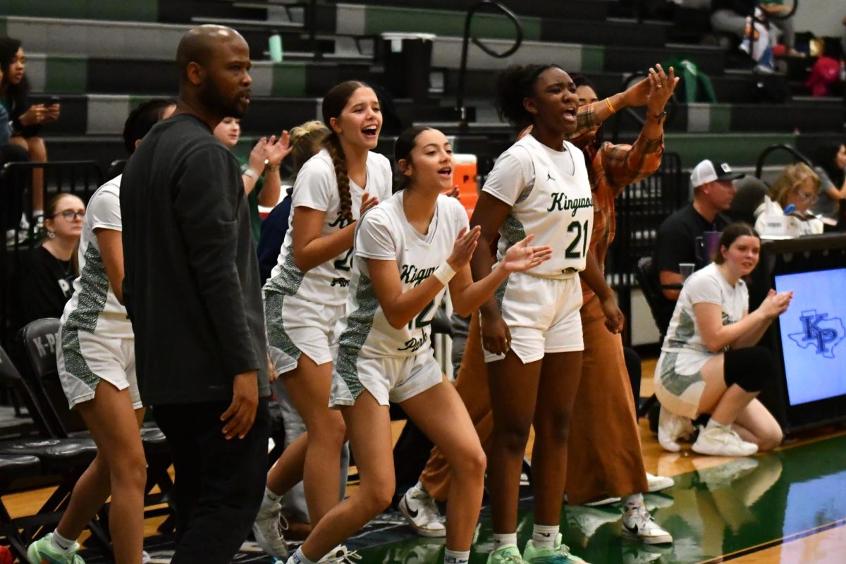 Varsity girls basketball players cheer for their teammates after the team scored a basket against Pasadena.