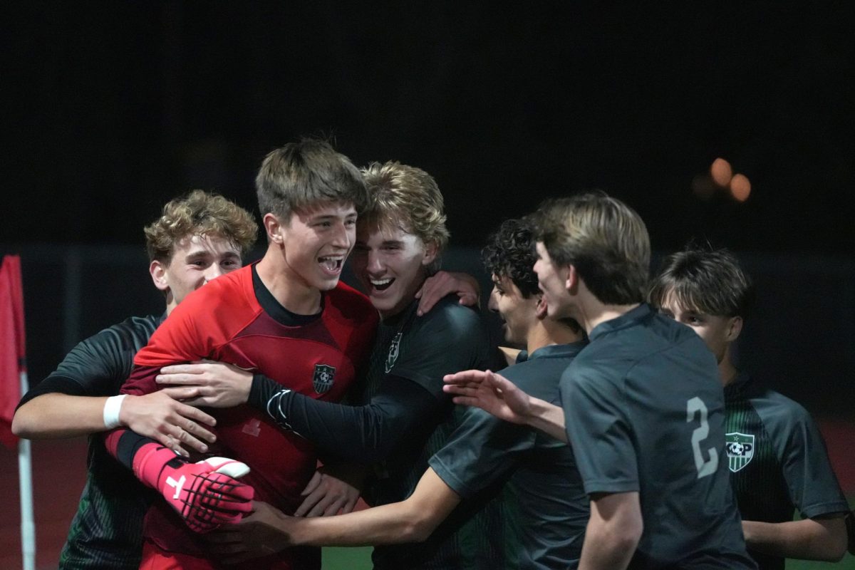 The Panthers surround junior goalkeeper Noah Laughlin after he scored the first goal of the game on a penalty kick.