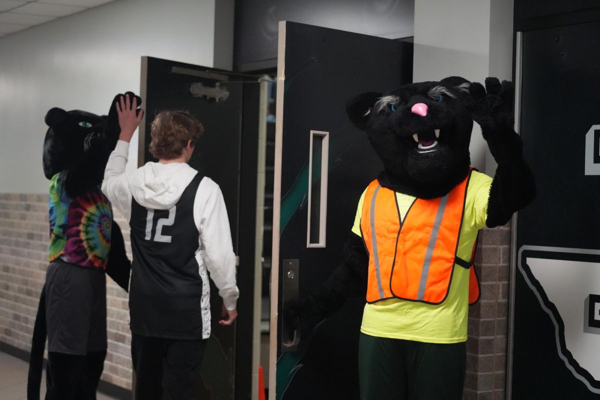 Paws, played by Jeremiah Head,
and Parker, played by Bennie Sweet,
welcome students to a pep rally with
high fives.