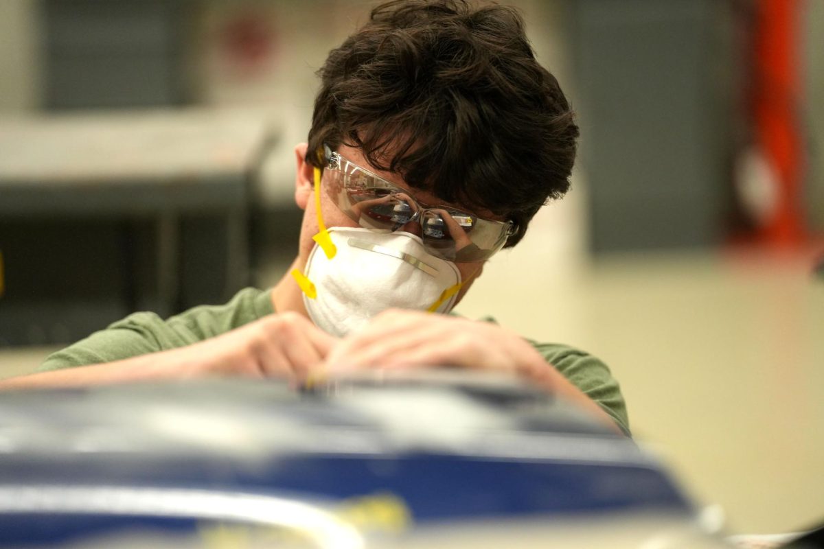 Junior Dylan Heady works on the body of a car during first period of the Collision Repair.  