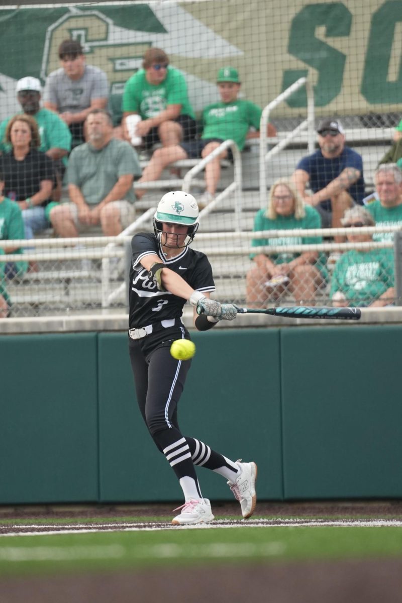 Junior Ava Klinefelter moves towards the ball as she prepares to swing in the first game of the playoff series against Brenham.