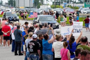 Community members hold up American flags while the procession for Shiloh Wilson passes. The procession for Wilson and his family took place on July 12. The Wilson family died in the Central Texas floods while camping in Kerrville.