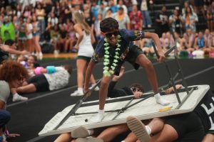 Junior Rayden DeSouza surfs the table in the first round of the table surfing competition against the sophomores on Aug. 29. The juniors defeated the sophomores and went on to beat the seniors in the finals.