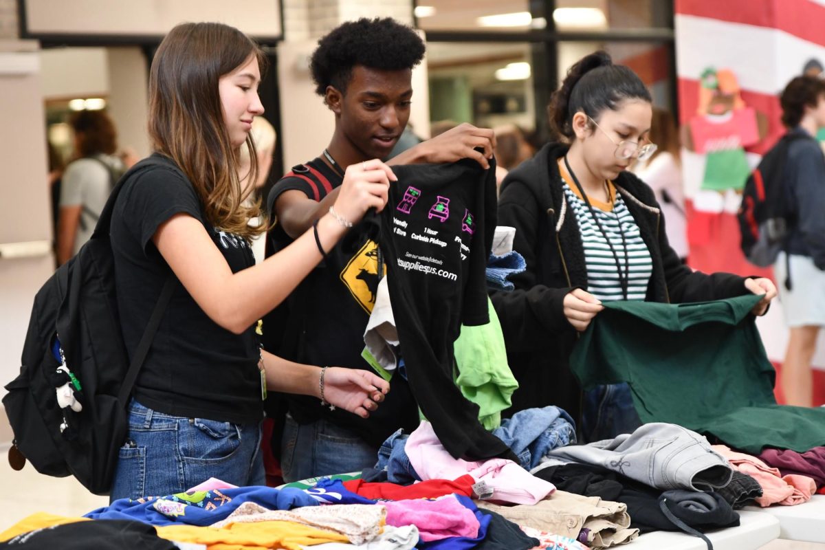 Seniors Mikayla Butler and Xavier Vital look through clothing options together during the popular Flex Hour Market in December 2023.