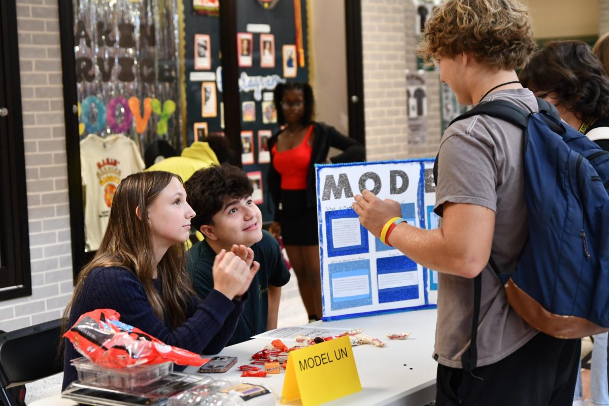 Seniors Jordan Glenn and Jorge Torres work at the Model UN table to recruit members during a club fair in September 2024 during Flex Hour. Student-created clubs are held during Flex Hour each day, offering students a break from the routine. During Flex Hour, students can also eat, hang out with friends, attend tutoring and relax. 