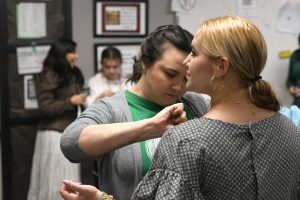 Theater director Brandi Perkins removes the boning from senior Emerson Harris's costume during seventh period on Sept. 3. 
