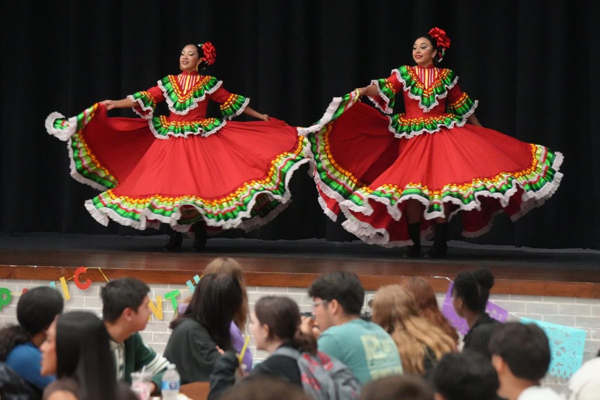 During two hours of lunch shifts, Ballet Folklórico dancers perform on the stage while students watch. The student group L.A.S.O. organized the performance during Hispanic Heritage Month.