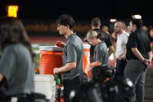 Freshman Vinny Russell refills water bottles as part of his duties as an athetlic trainer during the Homecoming football game on Oct. 3 against LaPorte.
