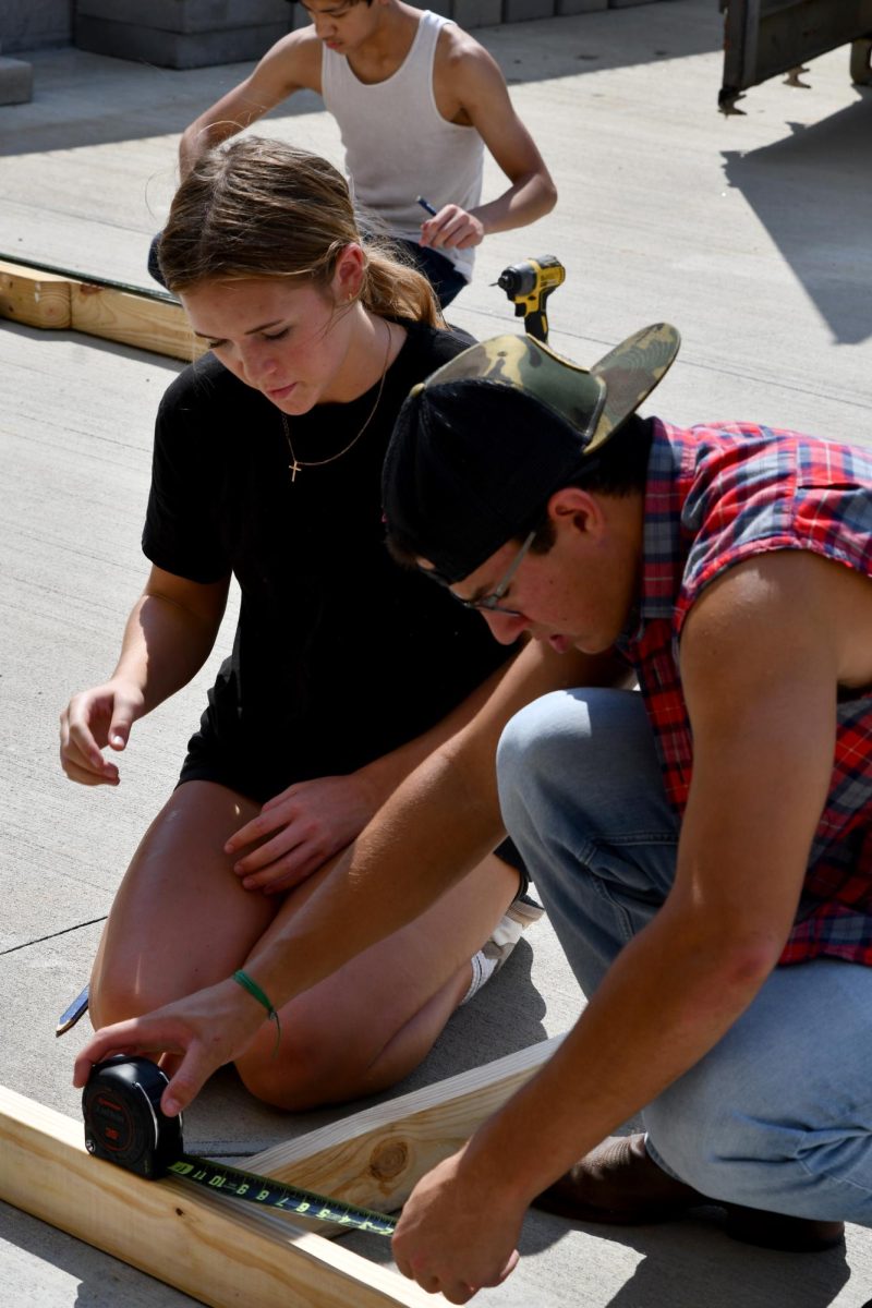 Seniors Sarah Du Preez and Michael Segura measure  pieces of wood during seventh period. 