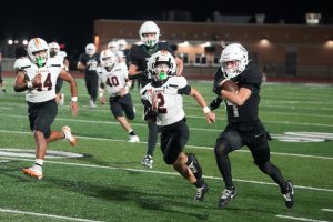 Running with a LaPorte defender, senior Bryce Gerbasich runs with the ball after catching a pass from sophomore quarterback Jon Pavlatos.