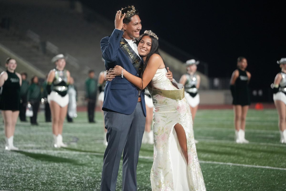 Seniors Eddie Hernandez and Janessa Rodriguez react after hearing their names announced as the King and Queen of Homecoming Week at halftime of the football game on Oct. 2. 