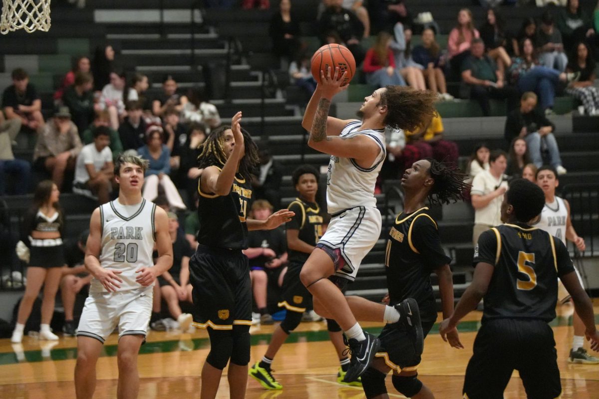 Senior Koltan Lopez jumps into the air, past the Alief Hastings defense, to shoot a layup towards the end of the game. The Panthers won the 'Silent Night' themed game, 52-40 against Alief Hastings.