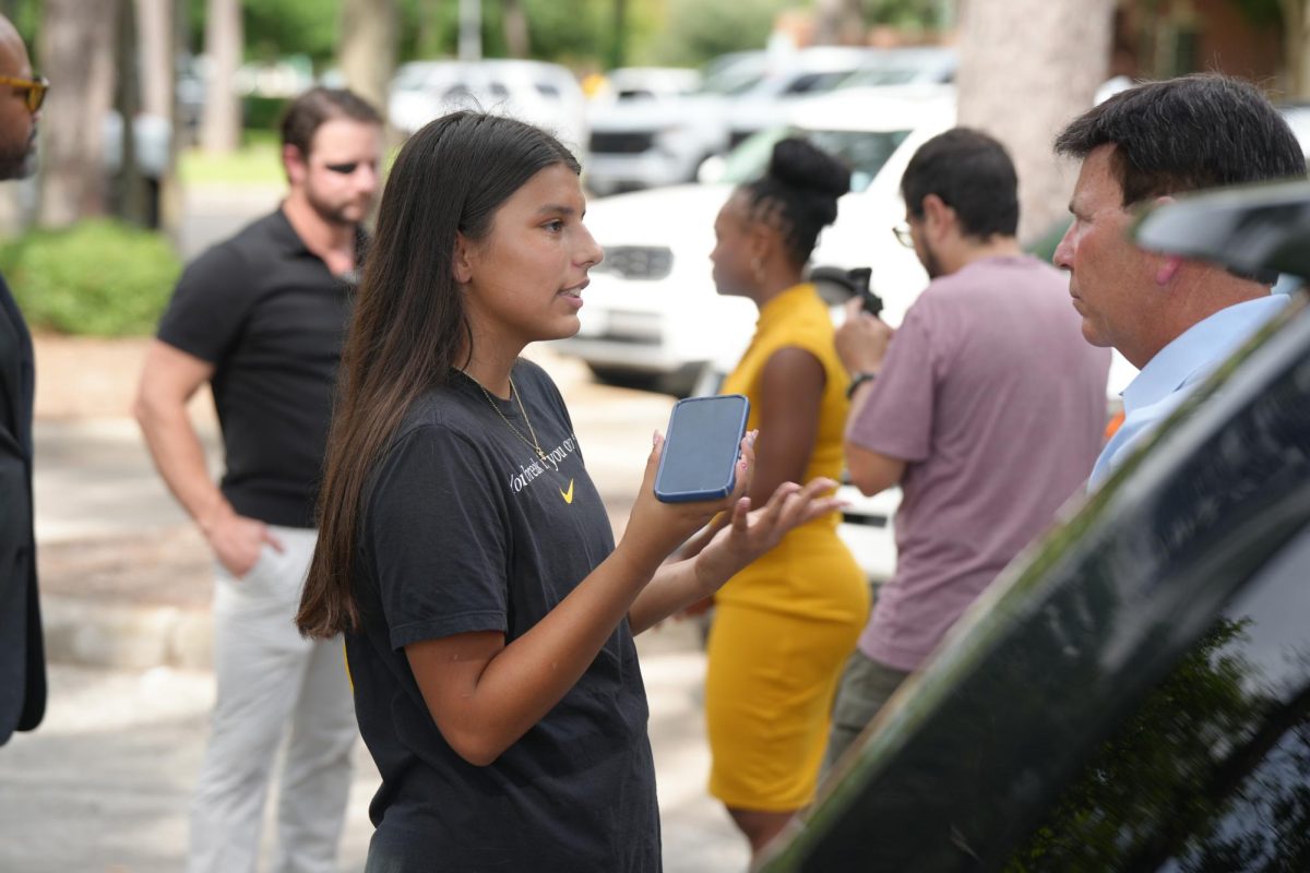 Junior Sydney Ortiz interviews Dr. Roger Brown in July at Kingwood Funeral Home, following the processional of Shiloh Wilson's body being brought to Kingwood. Wilson was the son of Kingwood Park teacher Jeff Wilson, whose family all died in the Central Texas floods. 