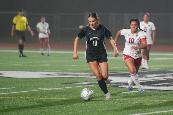 Junior Madison Moffitt runs with the ball away from a MacArthur player.