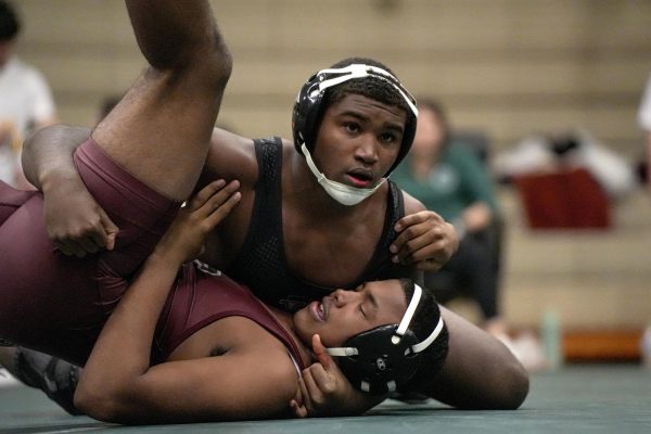 Looking toward the ref to see the call, senior Elijah Lester pins his opponent.