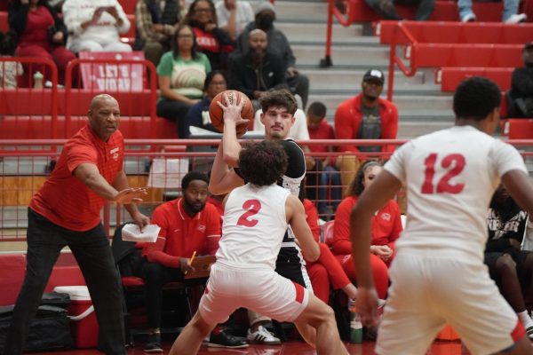 Sophomore Cole Hamilton looks for his teammates to pass the ball to, while the Crosby head coach demonstrates the defensive position to one of his players. 