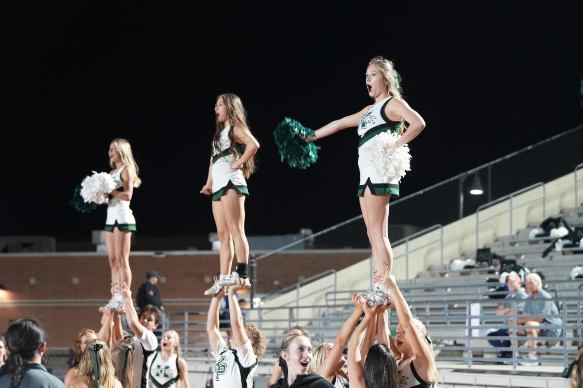 Cheerleaders perform during the varsity football game against Porter on Nov. 6. The cheerleaders have traded in the sidelines for center stage this week though as they prepare for their national competition in Florida. 
