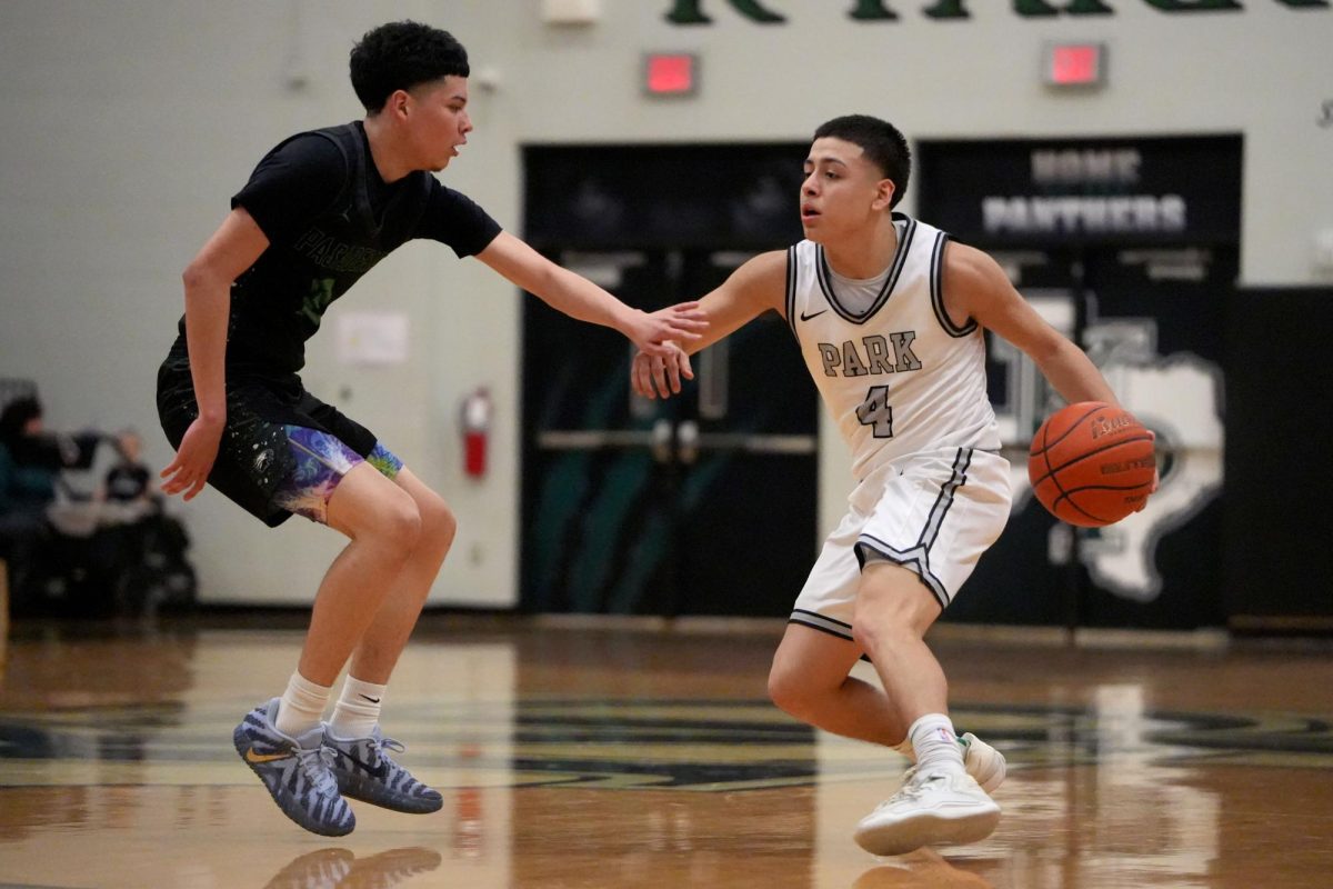 Looking past the three point line, senior Jesus Valenzuela dribbles the ball past a Pasadena player. On Feb. 17, the team competed in their last district game against Pasadena and won 46-42.