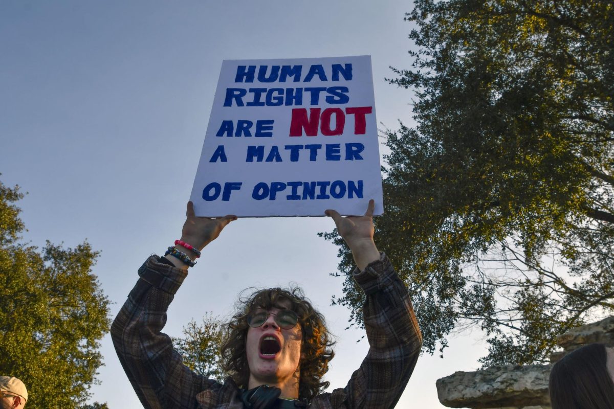 Students show off homemade signs while leading chants and waving to cars passing by during a peaceful protest on Feb. 6.