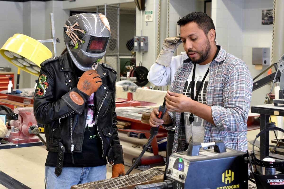 Junior Aaron Salazar listens as Automotive Basics teacher Valentin Medina explains a type of welding during fourth period class in January.