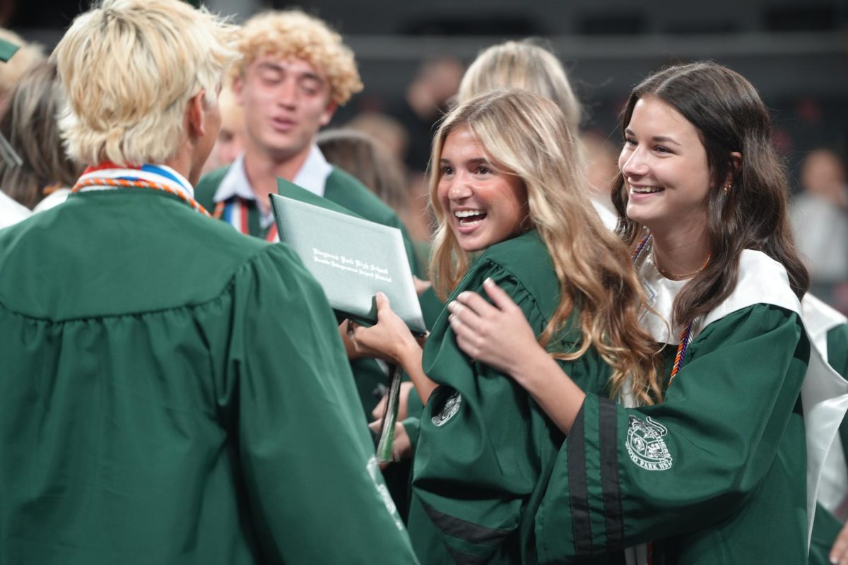 Seniors Madison Staggs and Ella Barker celebrate with Evan Carswell on the Fertitta Center court after the graduation ceremony officially ends on May 24. The Class of 2026 was the first to graduate on the UH campus since NRG Stadium was unavailable due to the upcoming FIFA World Cup games.