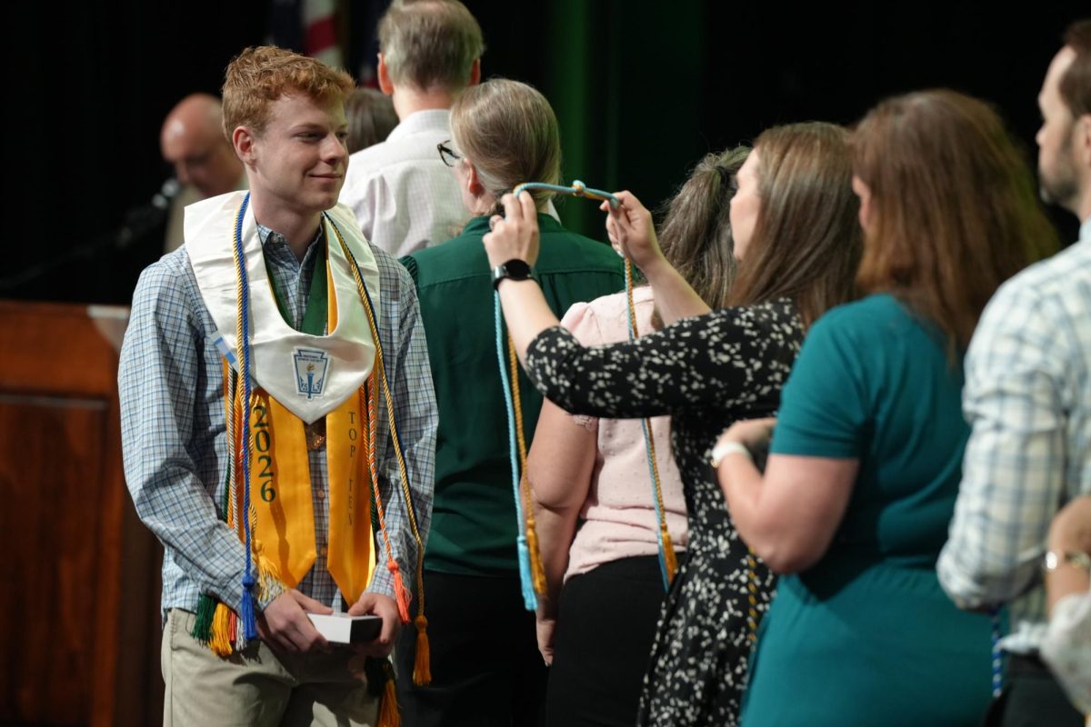 Senior William Burningham collects his stoles and cords during Honors Night on April 28. He will graduate No. 8 in the senior class. 