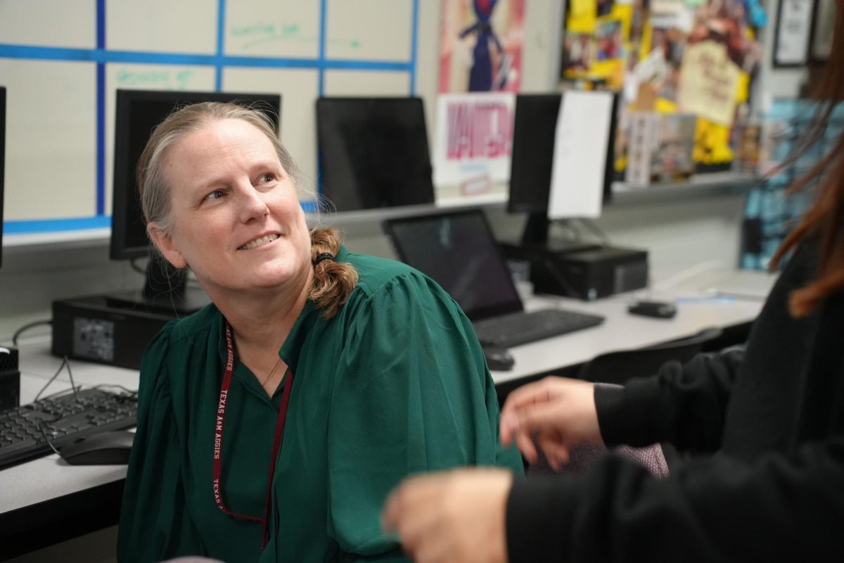 Journalism adviser Megan Ortiz talks with a student during newspaper class in early February.